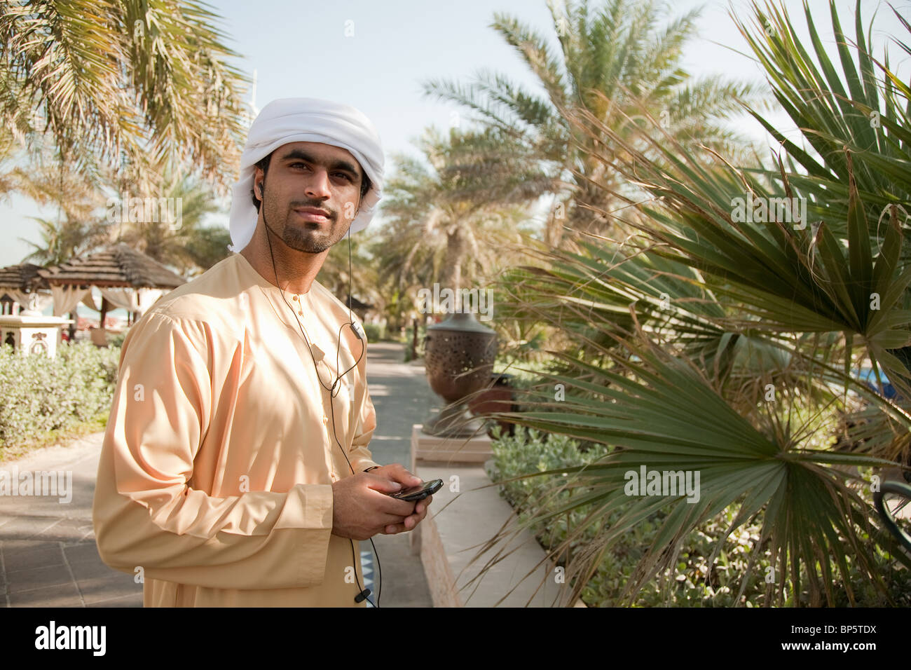 Middle Eastern man listening to music on mobile phone Stock Photo - Alamy