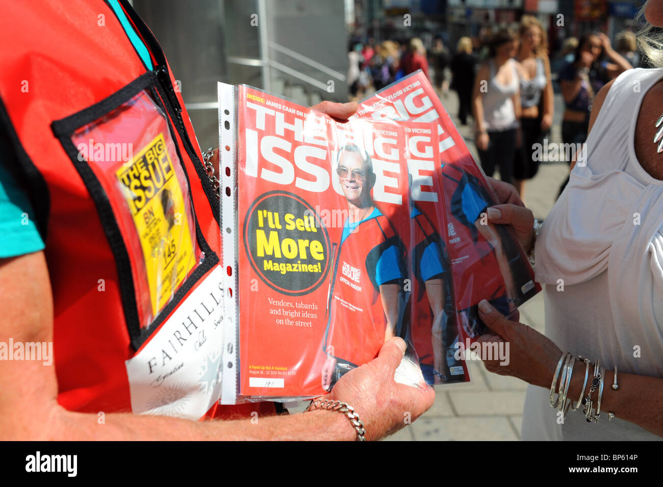 Official Big Issue seller vendor on streets of Brighton city centre UK Stock Photo