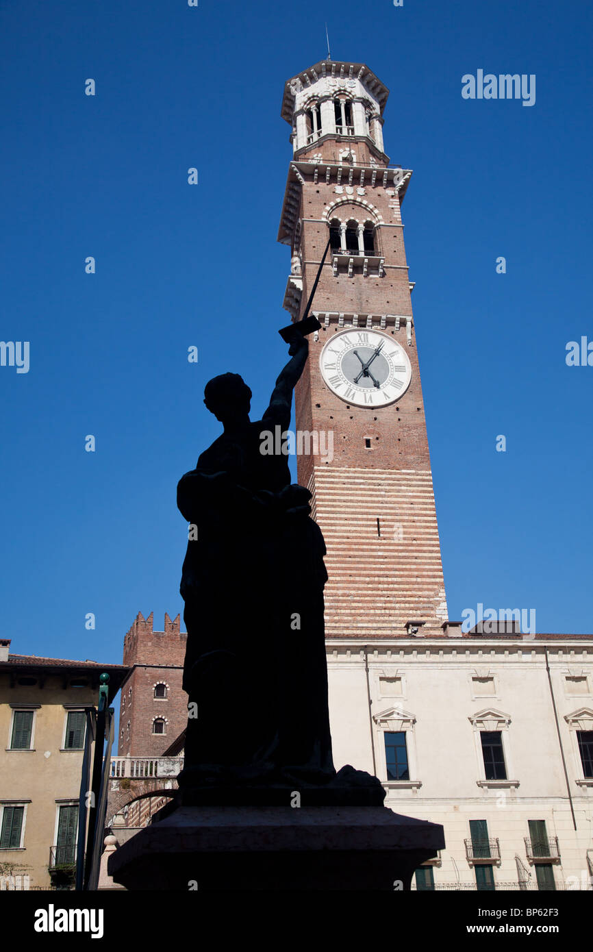Old statue points at Lamberti Tower in Erbe square in Verona Stock Photo