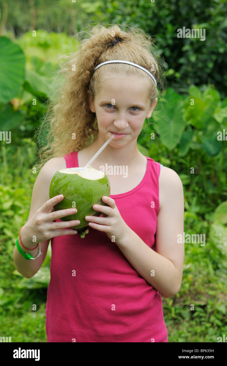 Girl, 11-12, drinking from a coconut, Chilamate, Costa Rica Stock Photo