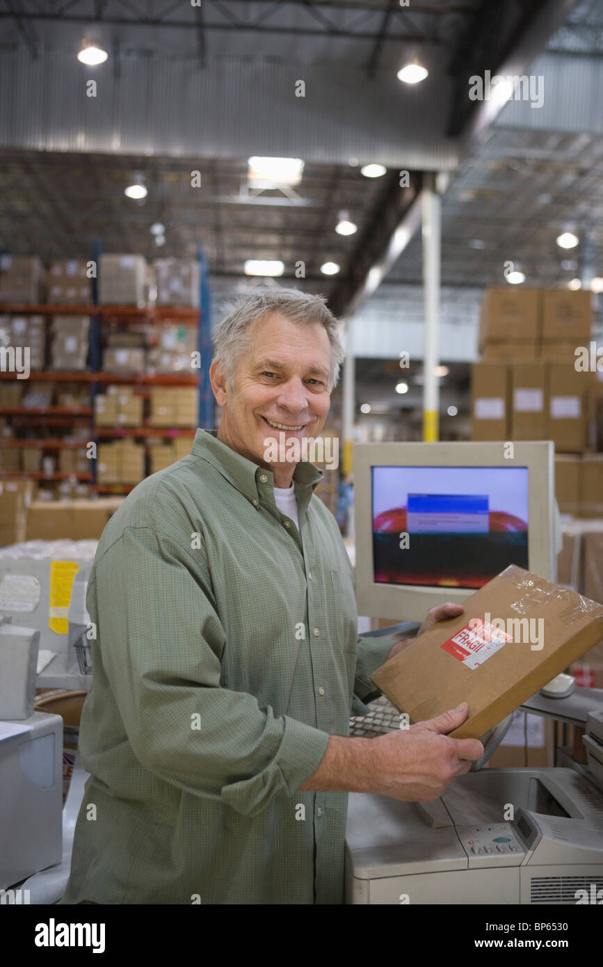 Cheerful man working in distribution warehouse Stock Photo