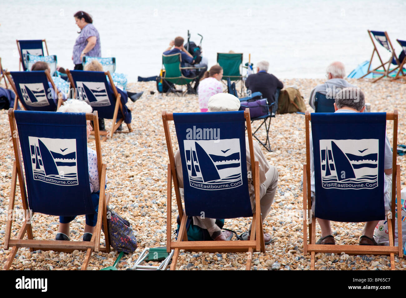 People sat in deck chairs on the beach at Eastbourne, East Sussex, UK Stock  Photo - Alamy