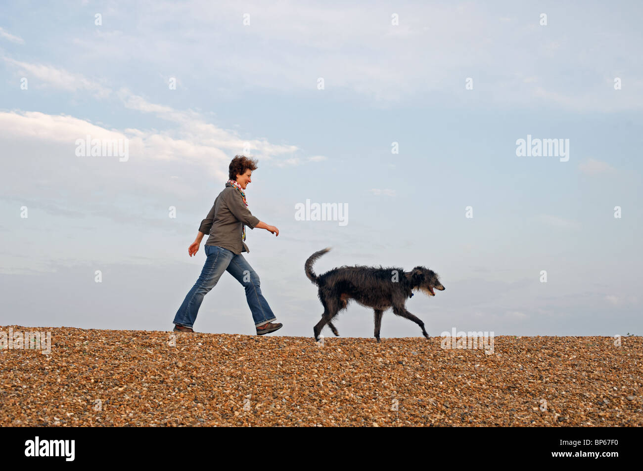 Woman walking her dog along the Suffolk Heritage coast Stock Photo