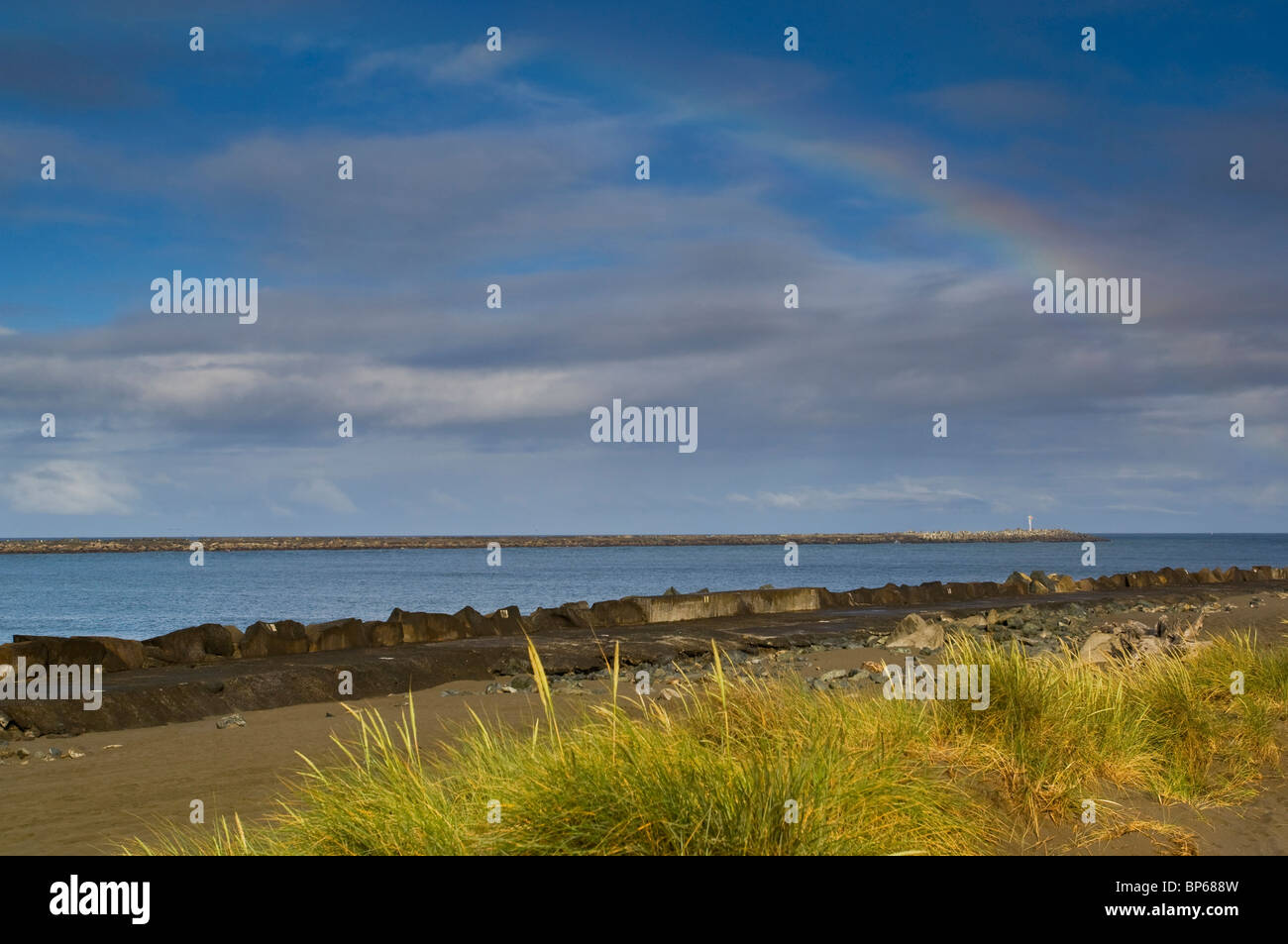 Rainbow over north and south jetties along the Entrance channel into Humboldt Bay, California Stock Photo