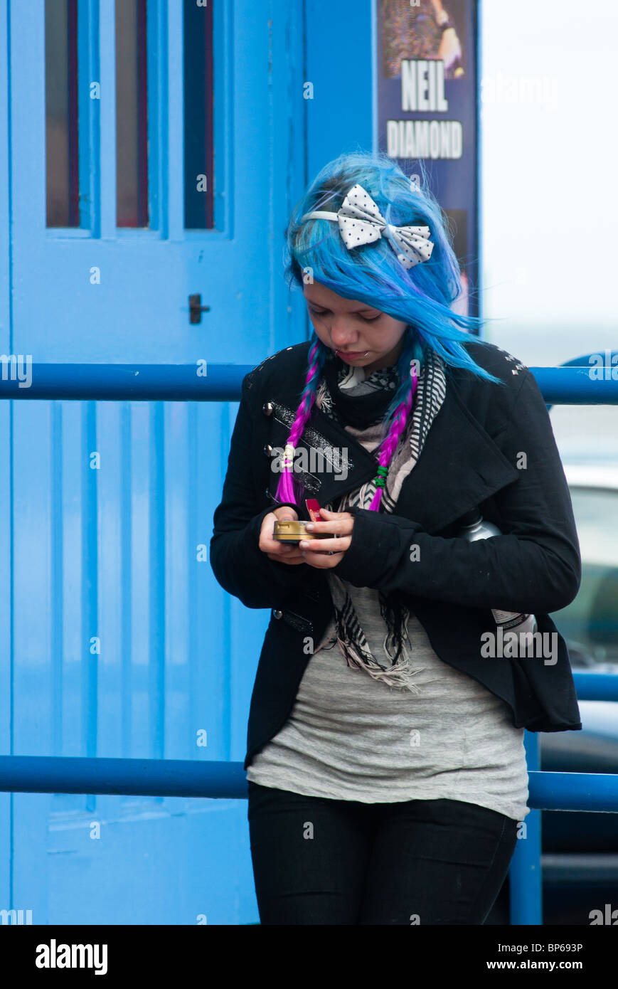 A blue haired girl seen in front of Blackpool's South Pier. Stock Photo