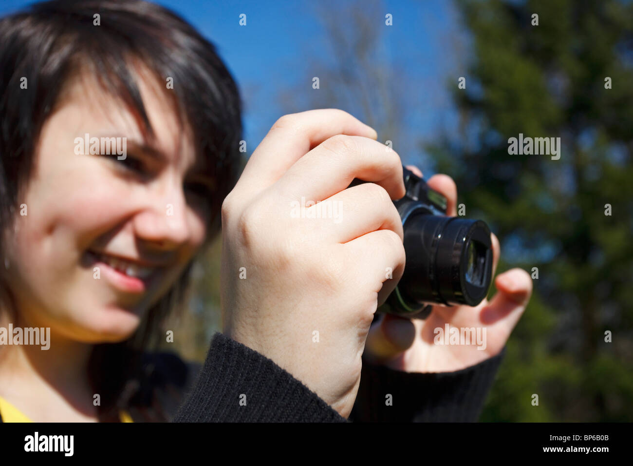 Portland, Oregon, United States Of America; A Teenage Girl Takes A Picture With Her Camera In A Park Stock Photo