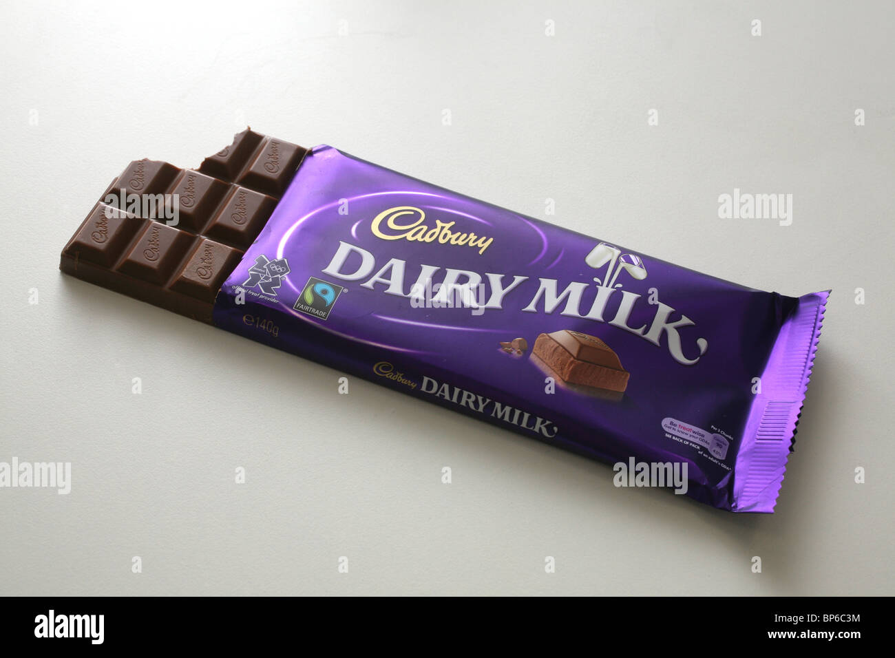 A bar of Cadbury Dairy Milk chocolate in it's wrapper with a bite ...