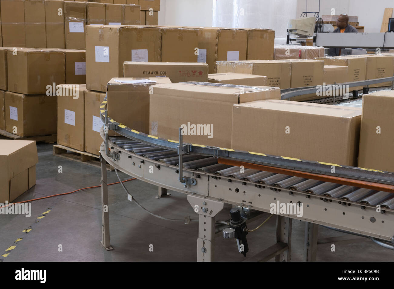Cardboard boxes on conveyor belt in distribution warehouse Stock Photo