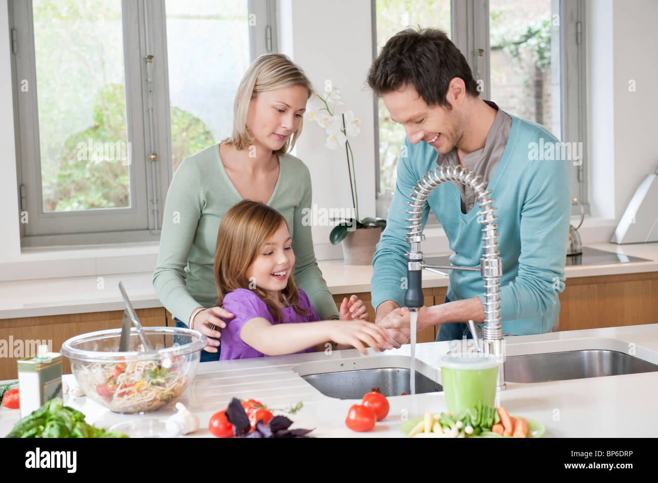 Family preparing food in the kitchen Stock Photo Alamy