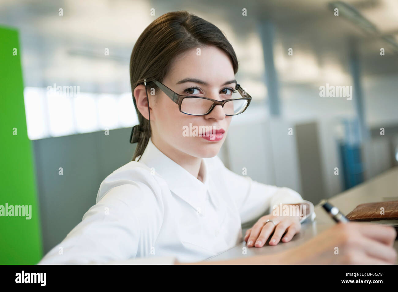 Look Over Spectacles Portrait of a businesswoman looking over eyeglasses Stock Photo - Alamy