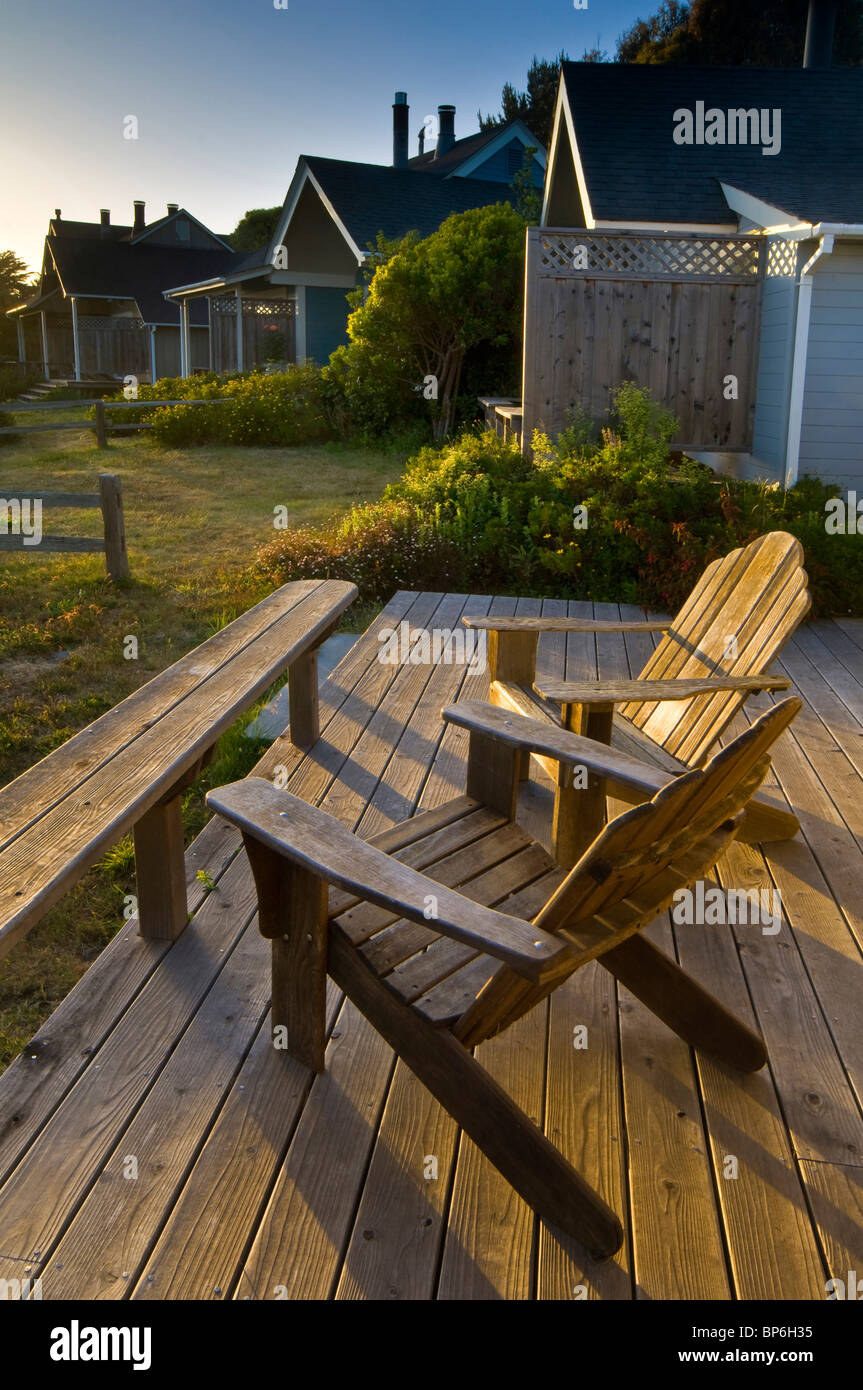 Wooden deck chairs and guest cottages at sunset, Albion River Inn, Albion, Mendocino County, California Stock Photo
