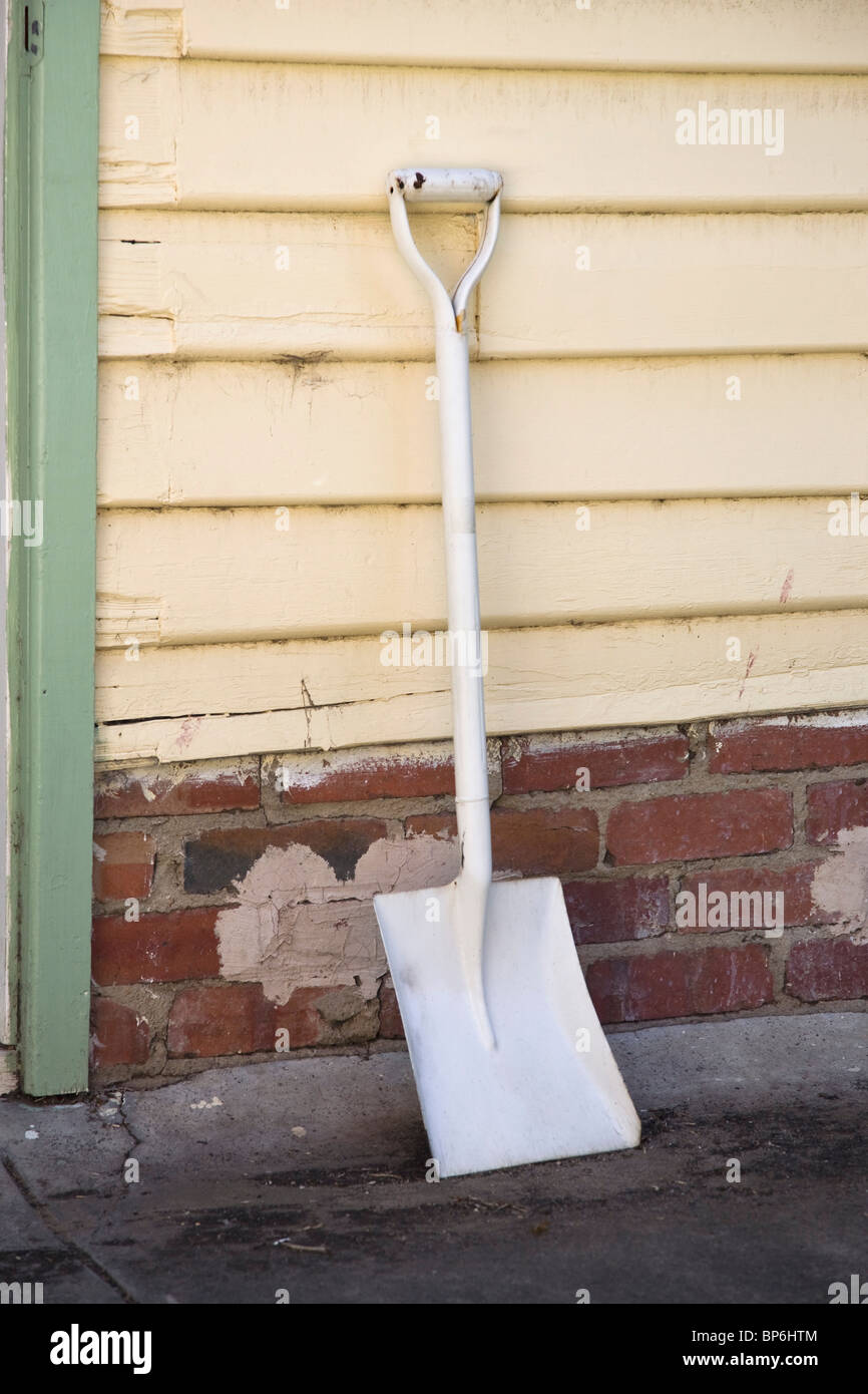 A shovel leaning against a wall Stock Photo