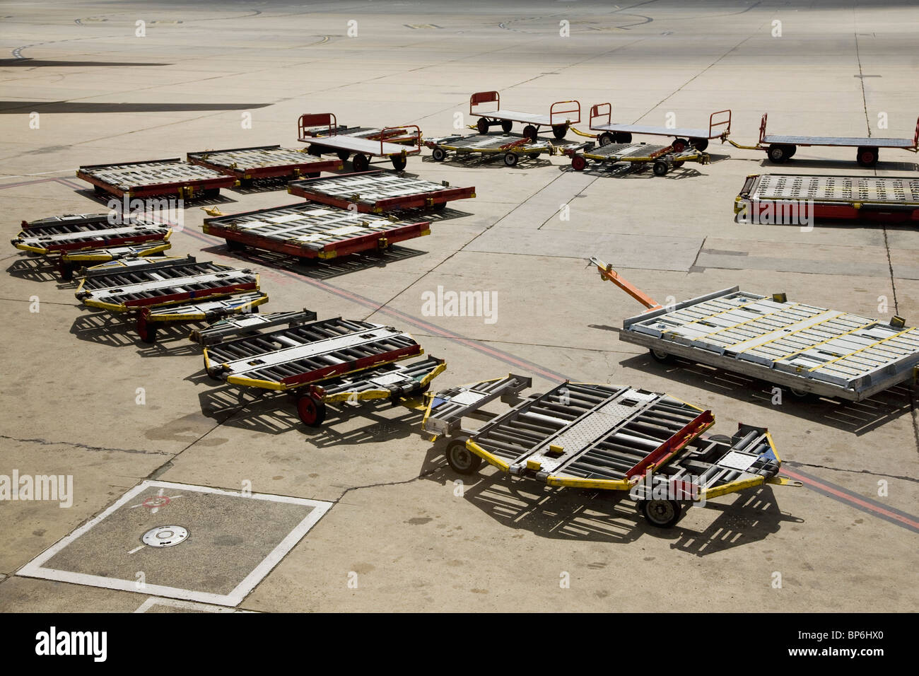 Baggage trailers on an airport tarmac Stock Photo
