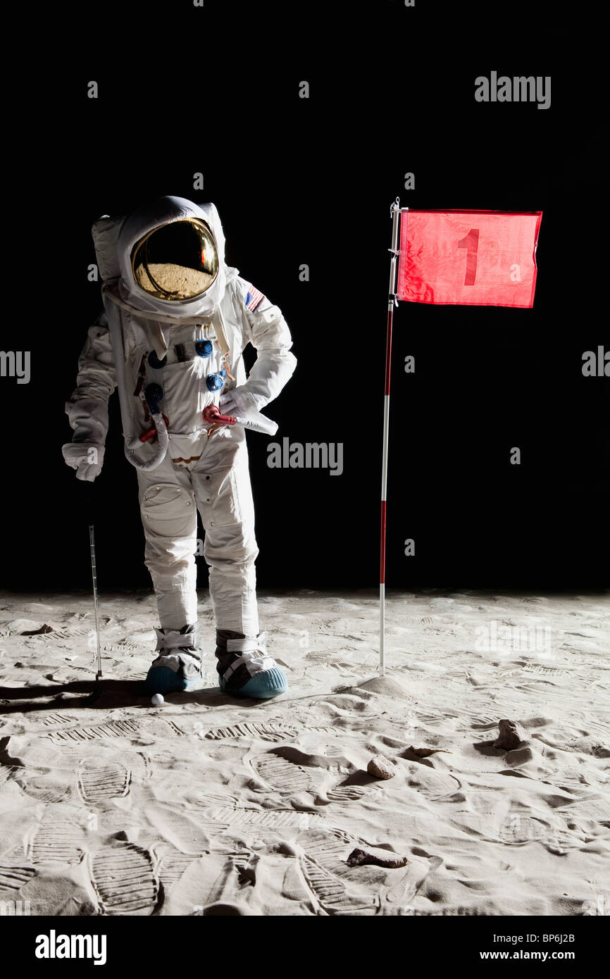 An astronaut on the moon standing next to number 1 hole flag Stock Photo