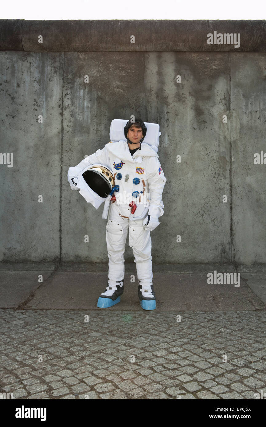An astronaut standing on a sidewalk in a city Stock Photo