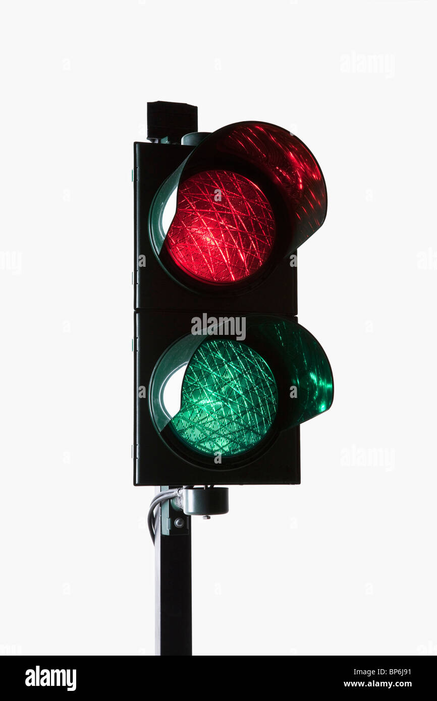 A stoplight with both the red light and green light illuminated Stock