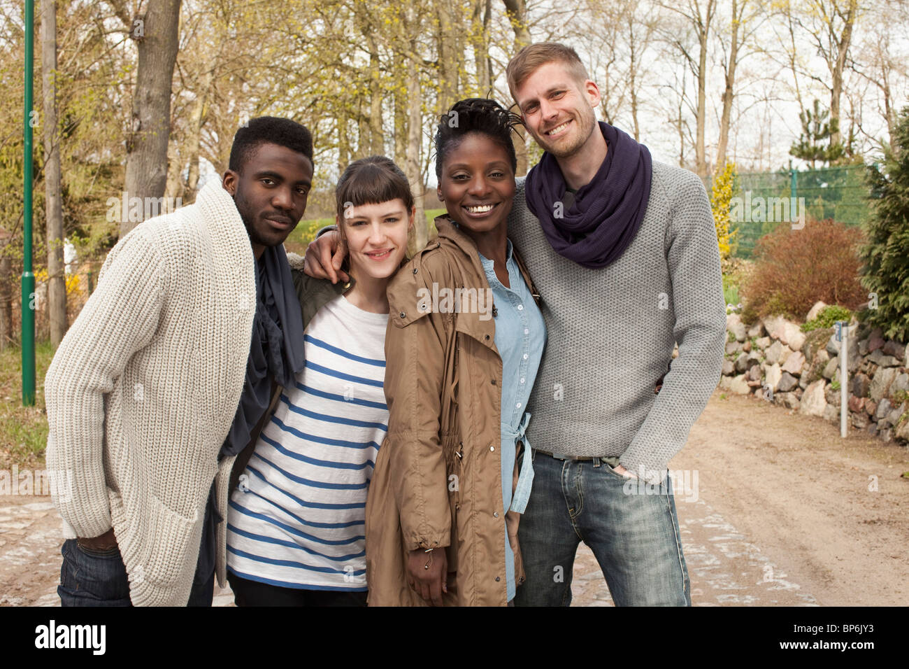 Four friends with their arms around each other Stock Photo