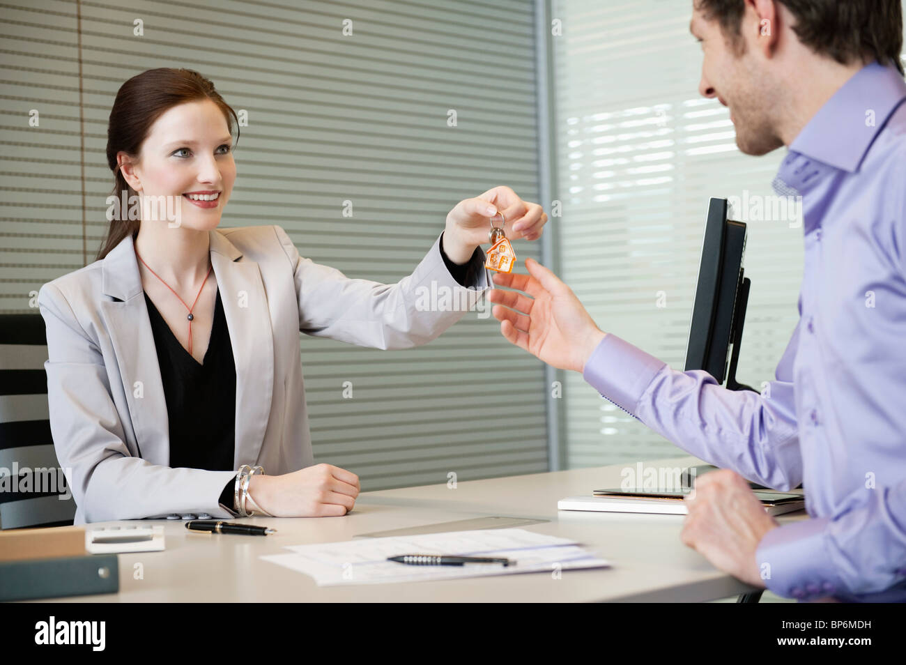 Female real estate agent giving house keys to a man Stock Photo - Alamy