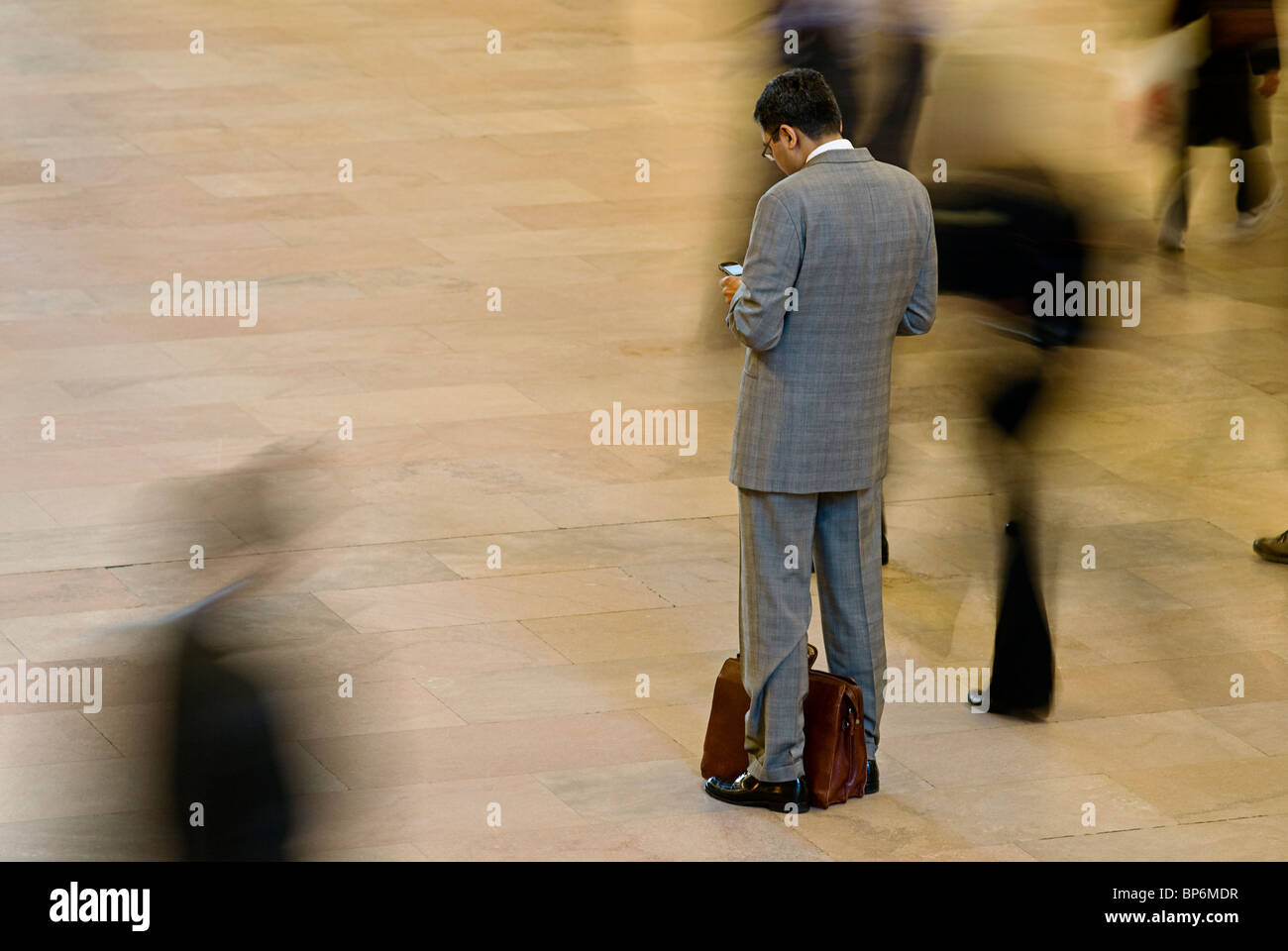 Business Man Looking at Cell Phone in Station Stock Photo