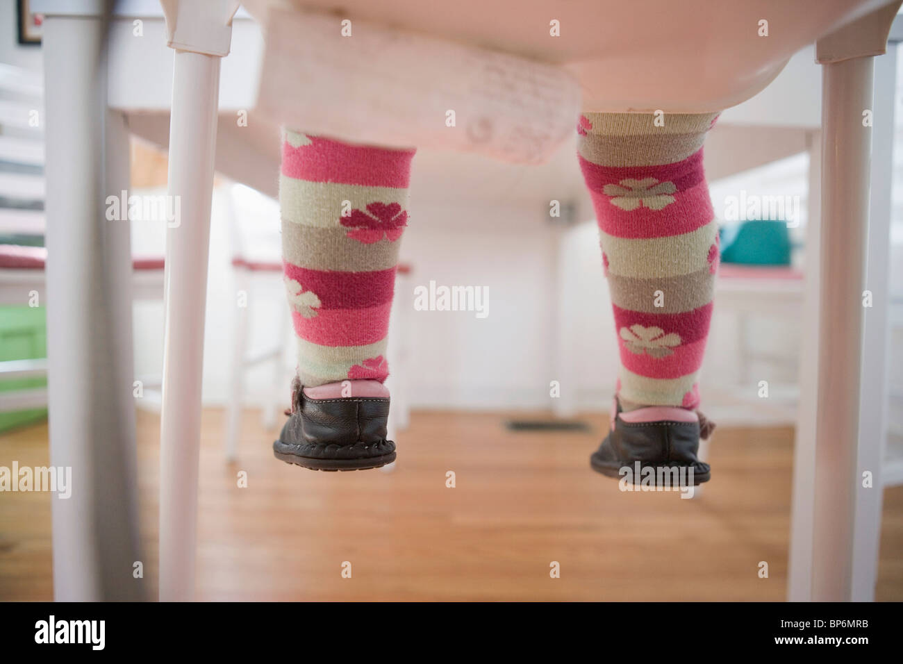 Low section of a baby girl sitting on a chair Stock Photo - Alamy