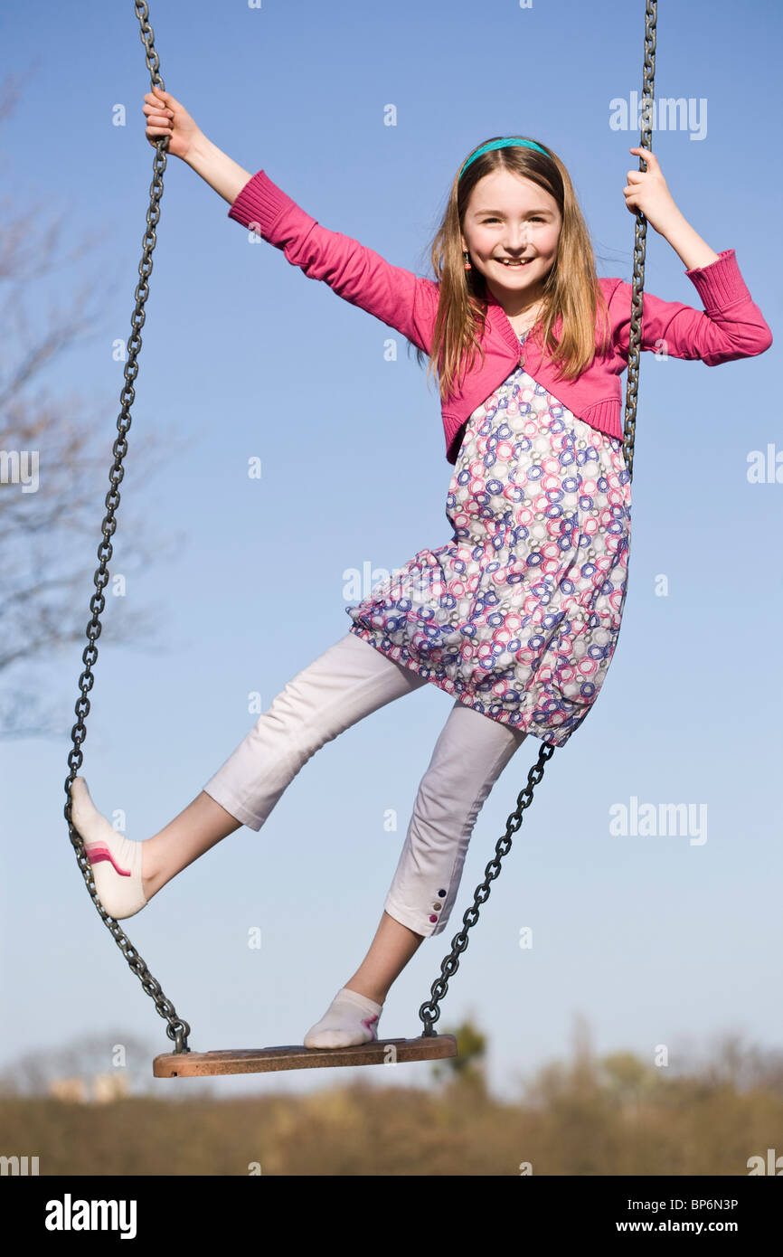 A girl standing on a swing Stock Photo - Alamy