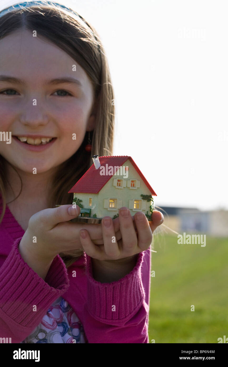 A girl holding a miniature house Stock Photo - Alamy