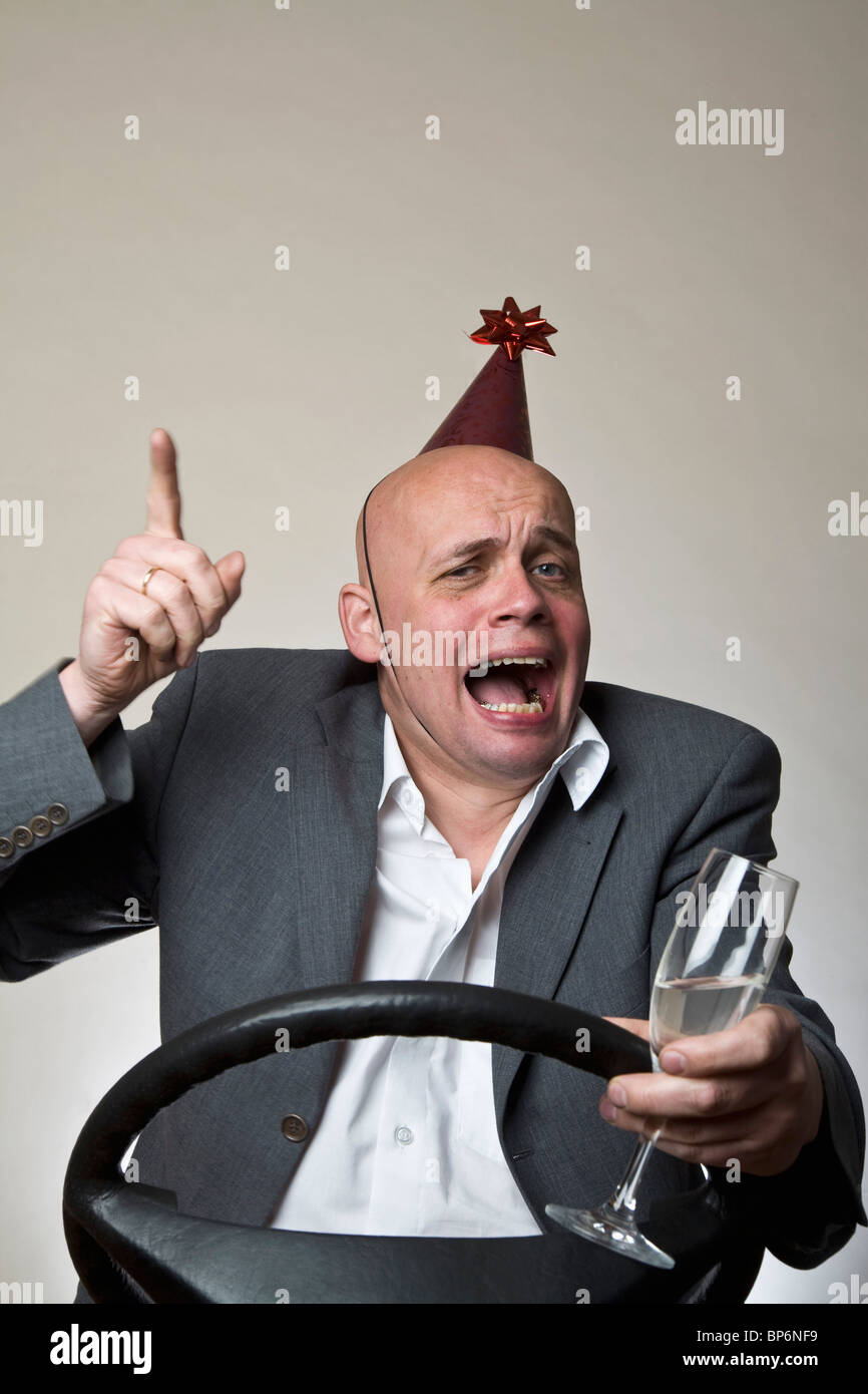 A drunk man behind a car steering wheel Stock Photo