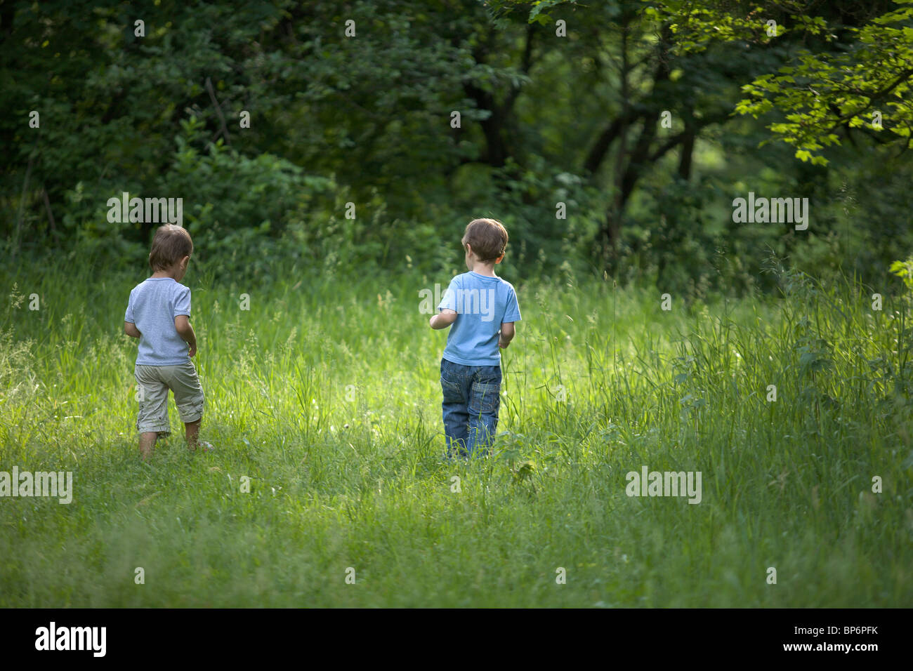 Two young boys walking outdoors in summer Stock Photo