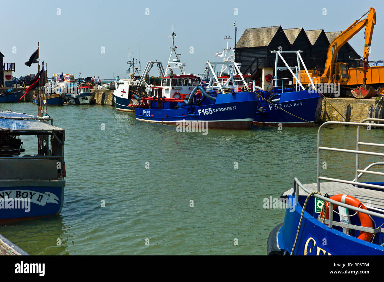 View across Whitstable Harbour with moored fishing boats Stock Photo ...