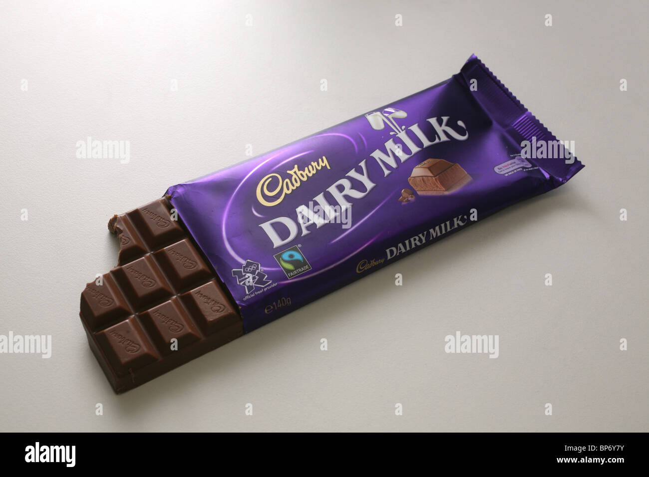 A bar of Cadbury Dairy Milk chocolate in it's wrapper with a bite taken out of it. Stock Photo