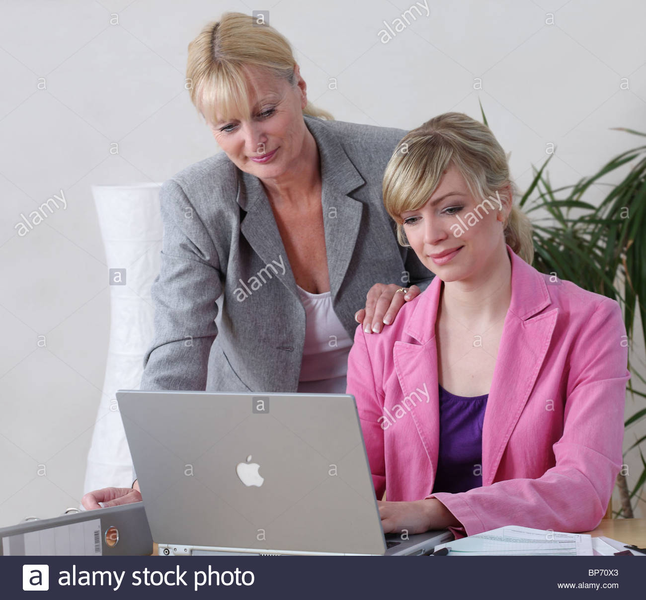 women sitting behind laptop Stock Photo