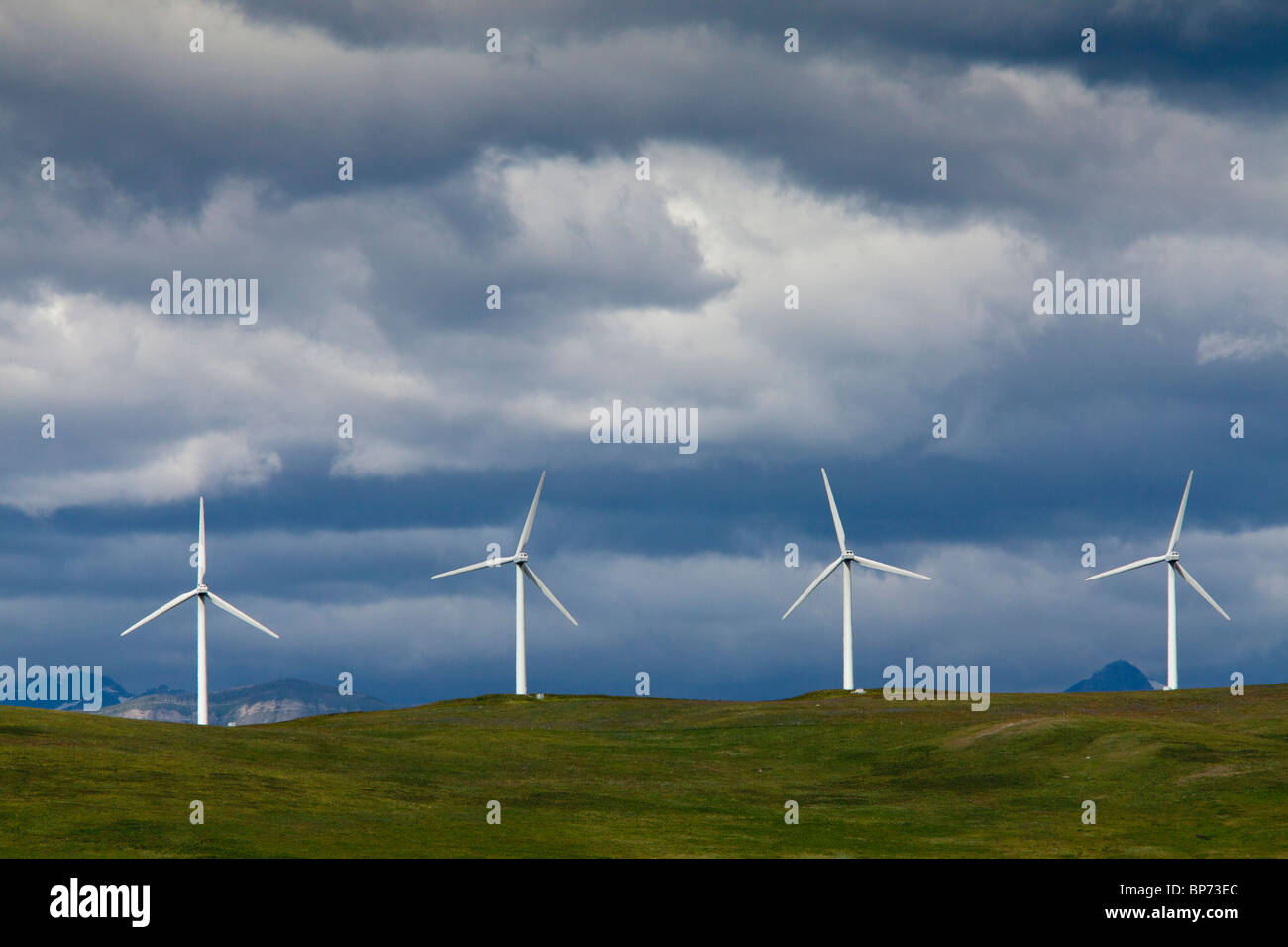 Windmills at Pincher Creek, Alberta, with the Rockies beyond, in stormy weather; Canada Stock Photo