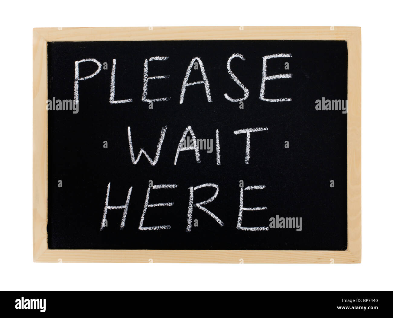 A message, "Please Wait Here" on a chalkboard. Stock Photo