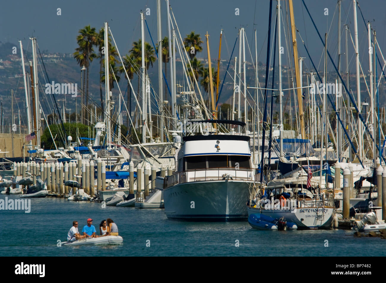 People in zodiac raft passing sailboats and yachts in Dana Point Harbor