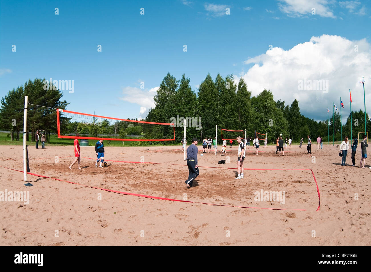Volleyball ground on sand beach and sportsmen playing the game