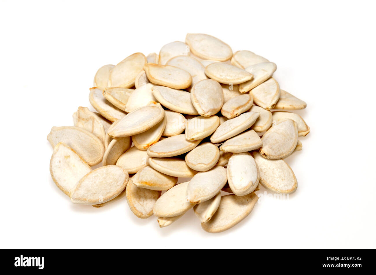 Loose pile of roasted Pumpkin Seeds isolated on white background cutout. Stock Photo