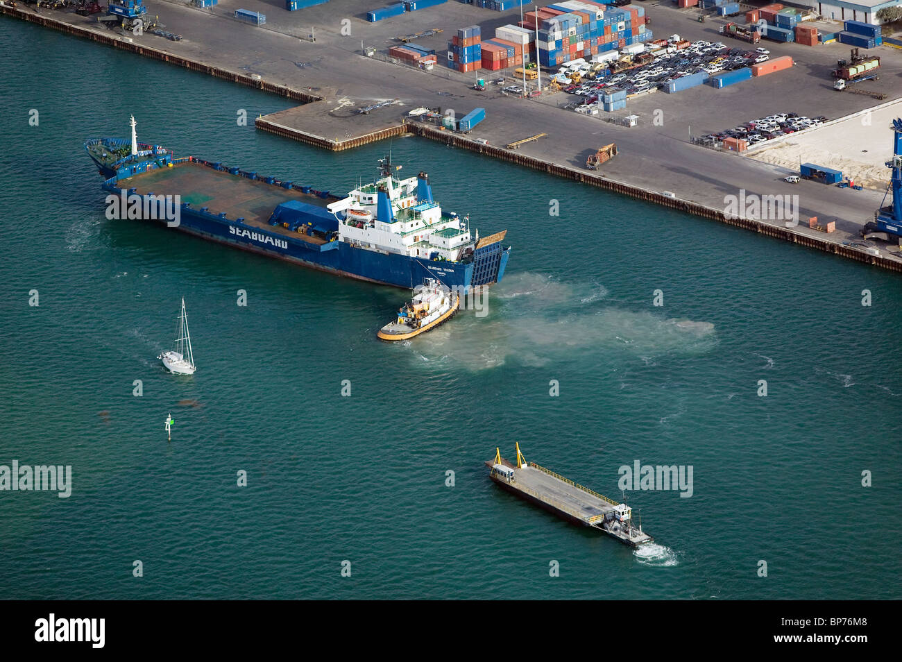 aerial view above Seabord Trader freight ship pushed by tugboat Port of Miami Florida Stock Photo