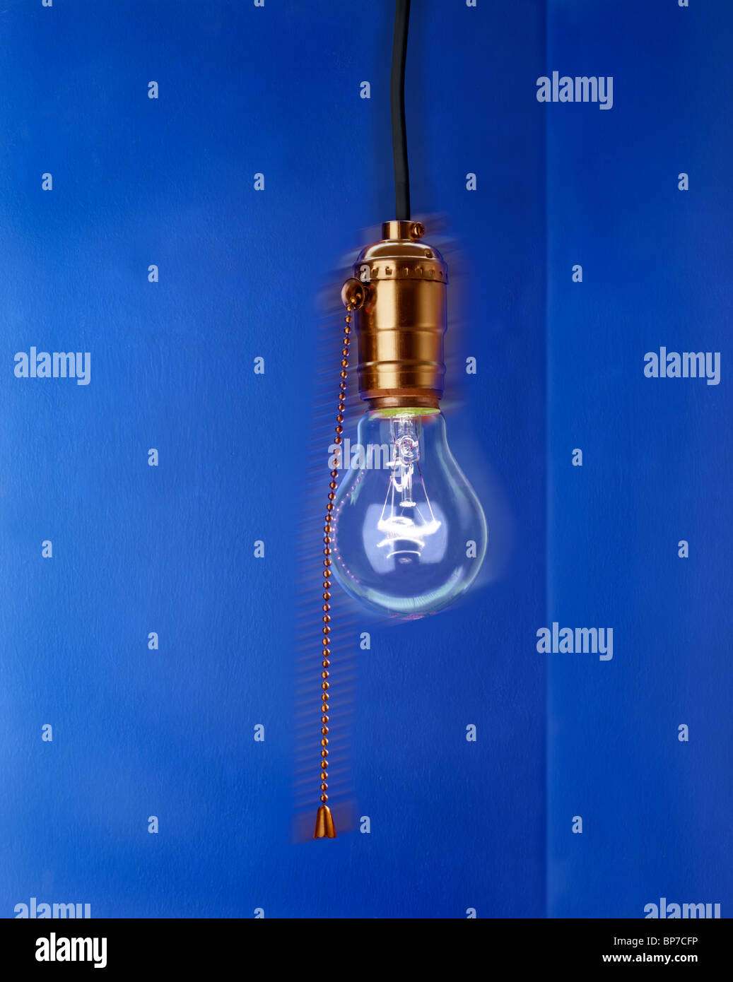 Single hanging bare lightbulb in old fashioned brass socket with