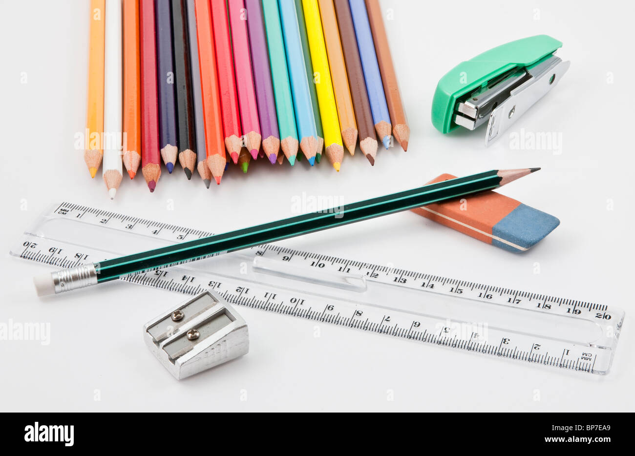 School supplies with colored pencils, pencil, eraser, sharpener, stapler and plastic ruler Stock