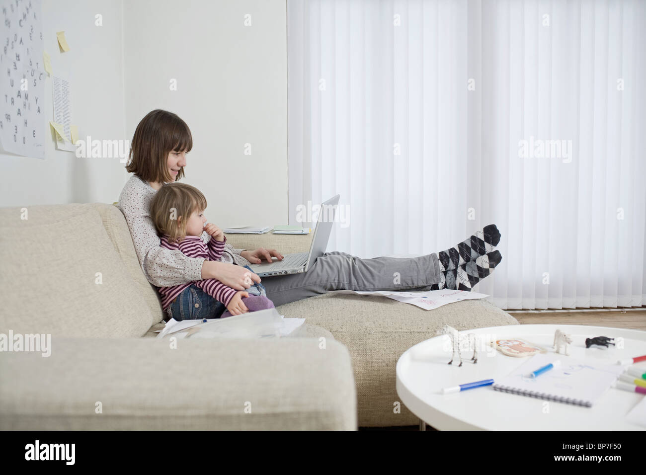Mother and daughter with laptop in living room Stock Photo - Alamy