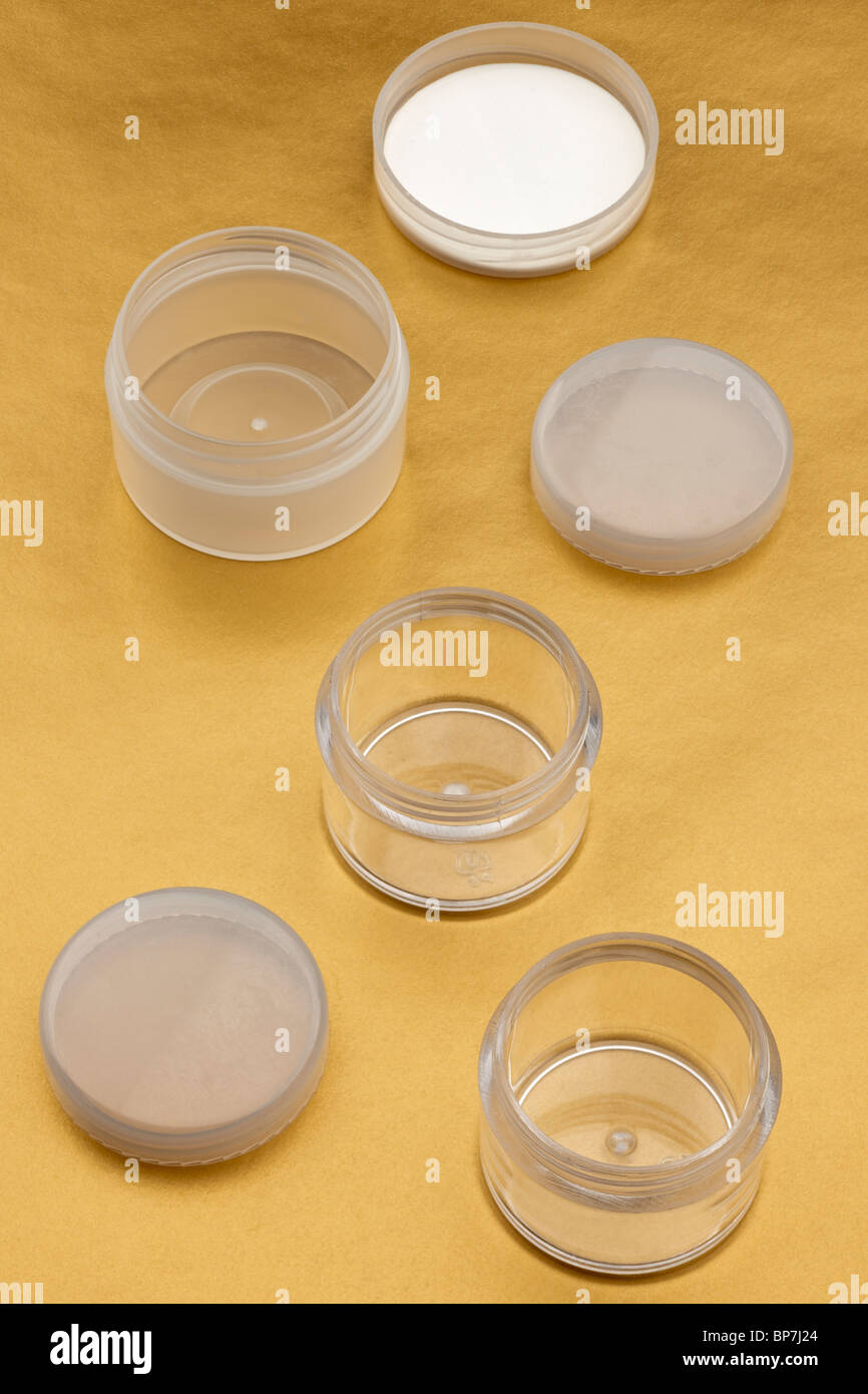 Three small clear empty plastic cosmetic containers with screw tops Stock Photo