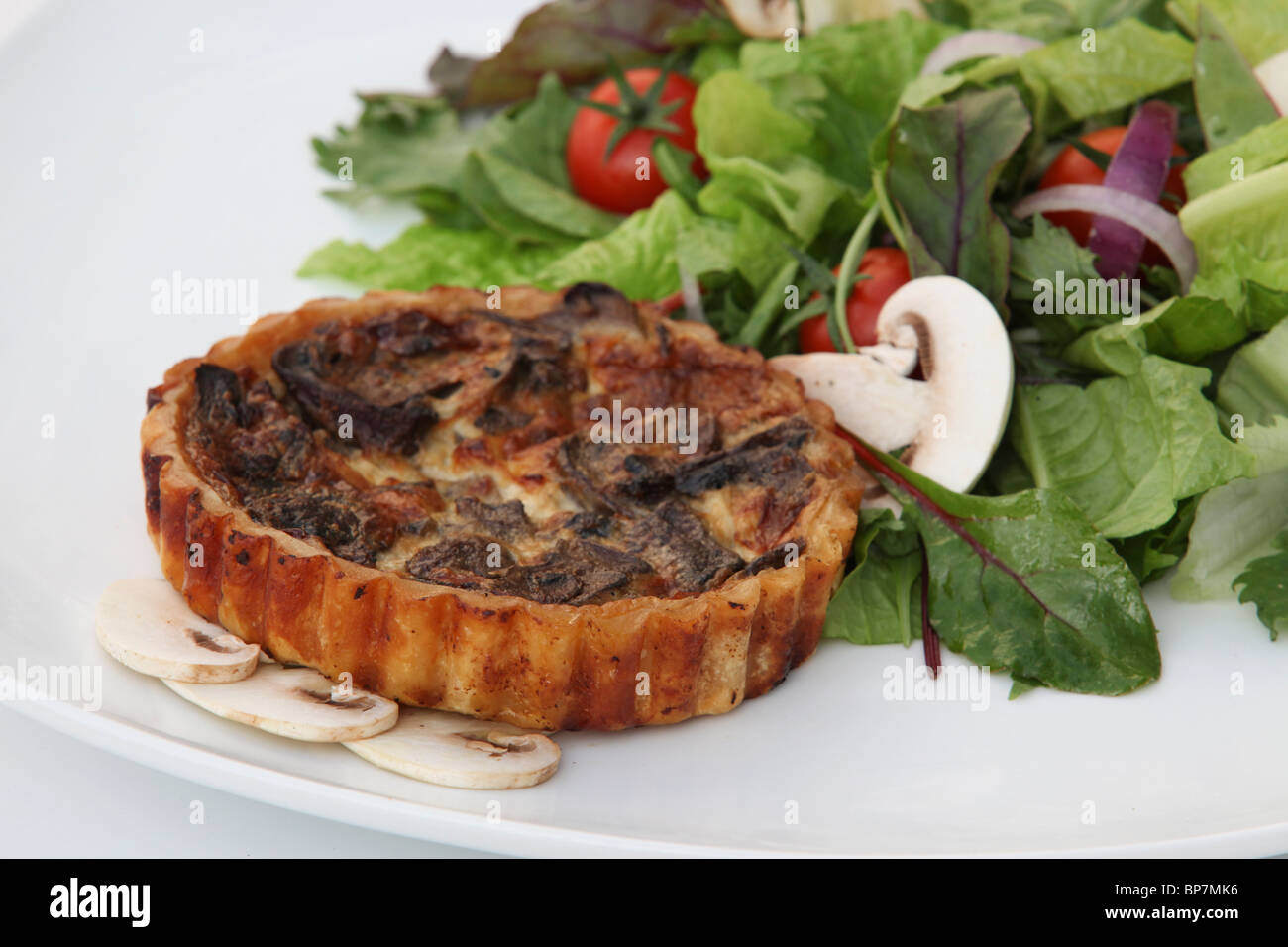 Savoury individual quiche tart with green salad Stock Photo Alamy