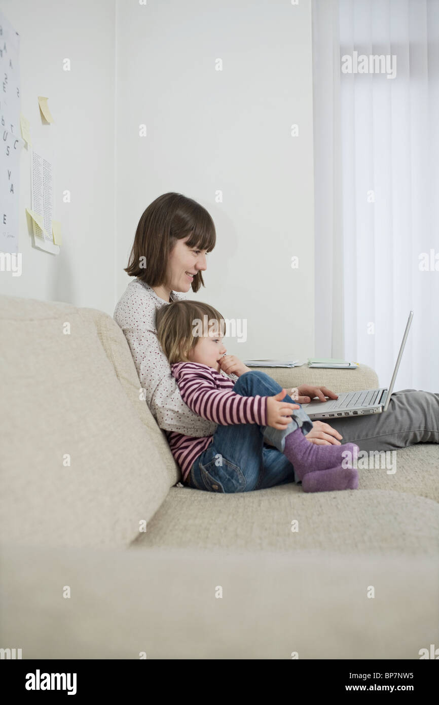 Mother and daughter with laptop in living room Stock Photo - Alamy
