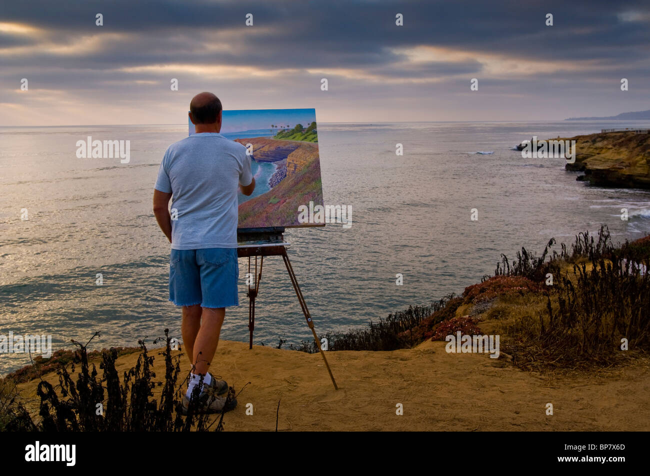 Artist Bill Jewell plein aire painting on coastal bluff overlooking the ocean at Sunset Cliffs, San Diego, California Stock Photo