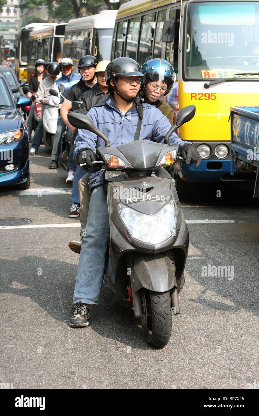 Motorcyclists stopping at traffic lights, Macao, China Stock Photo