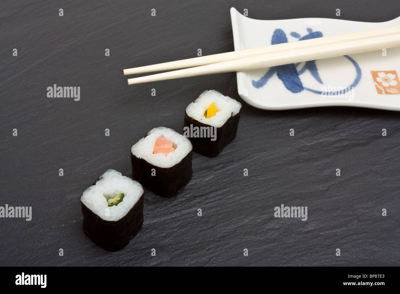 Sushi and chopsticks on dark grey slate background. Stock Photo