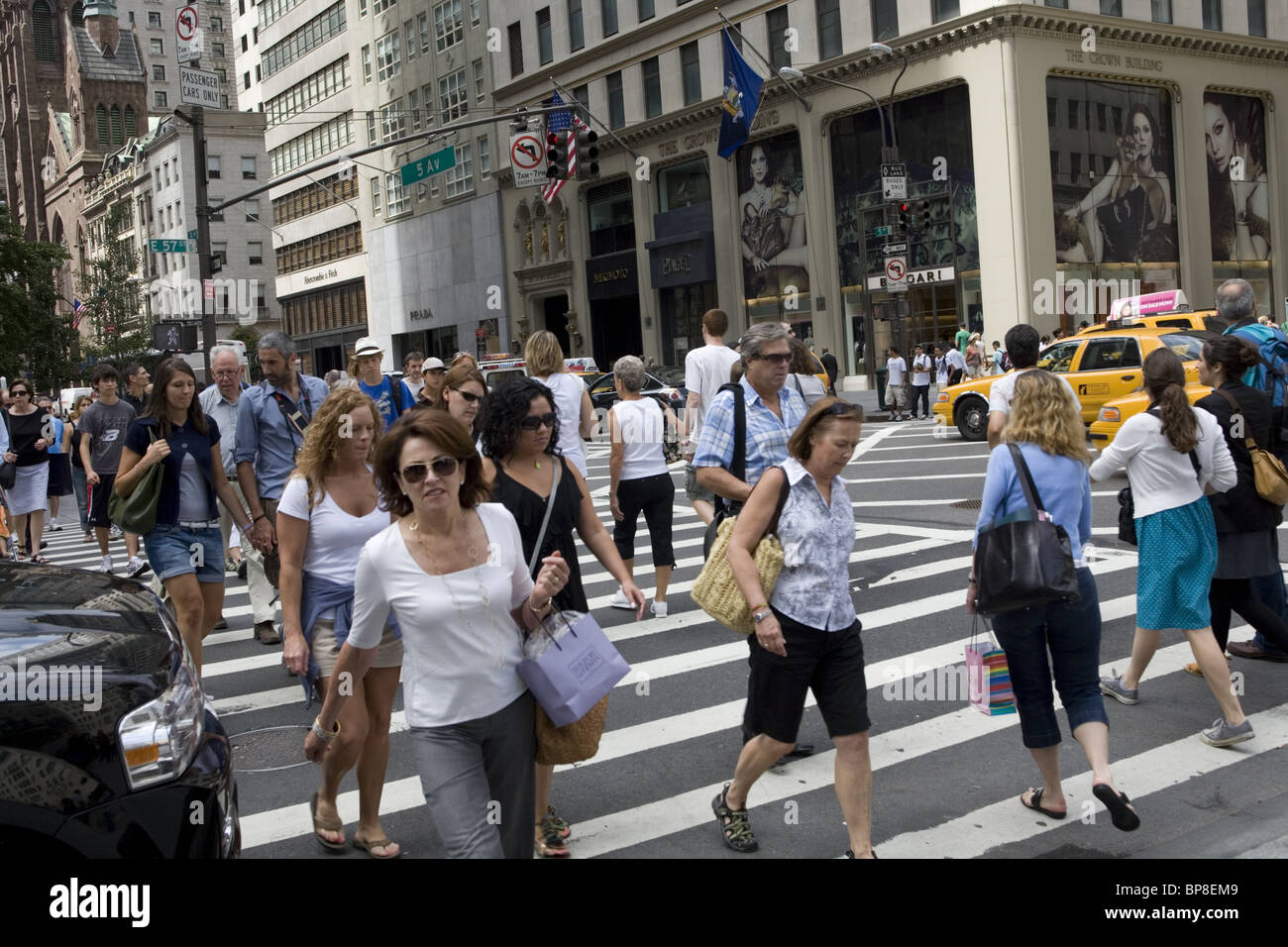 There are always a mixture of shoppers, tourists and New Yorkers along 5th Avenue at 57th Street in New York City. Stock Photo