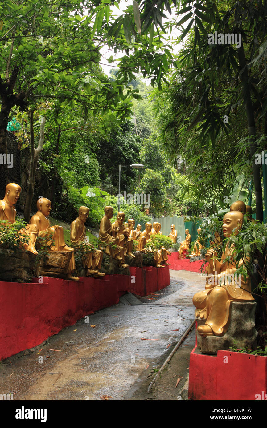 Gold painted Buddha statues line the path to the Ten Thousand Buddhas monastery, Sha Tin, Hong Kong Stock Photo