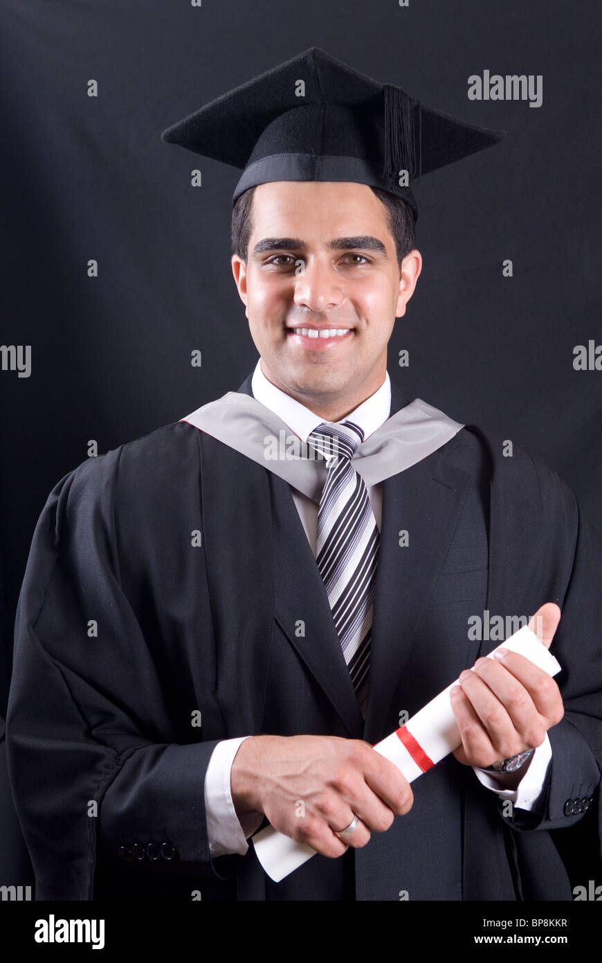 Young university graduate in graduation cap and gown holding diploma Stock Photo Alamy