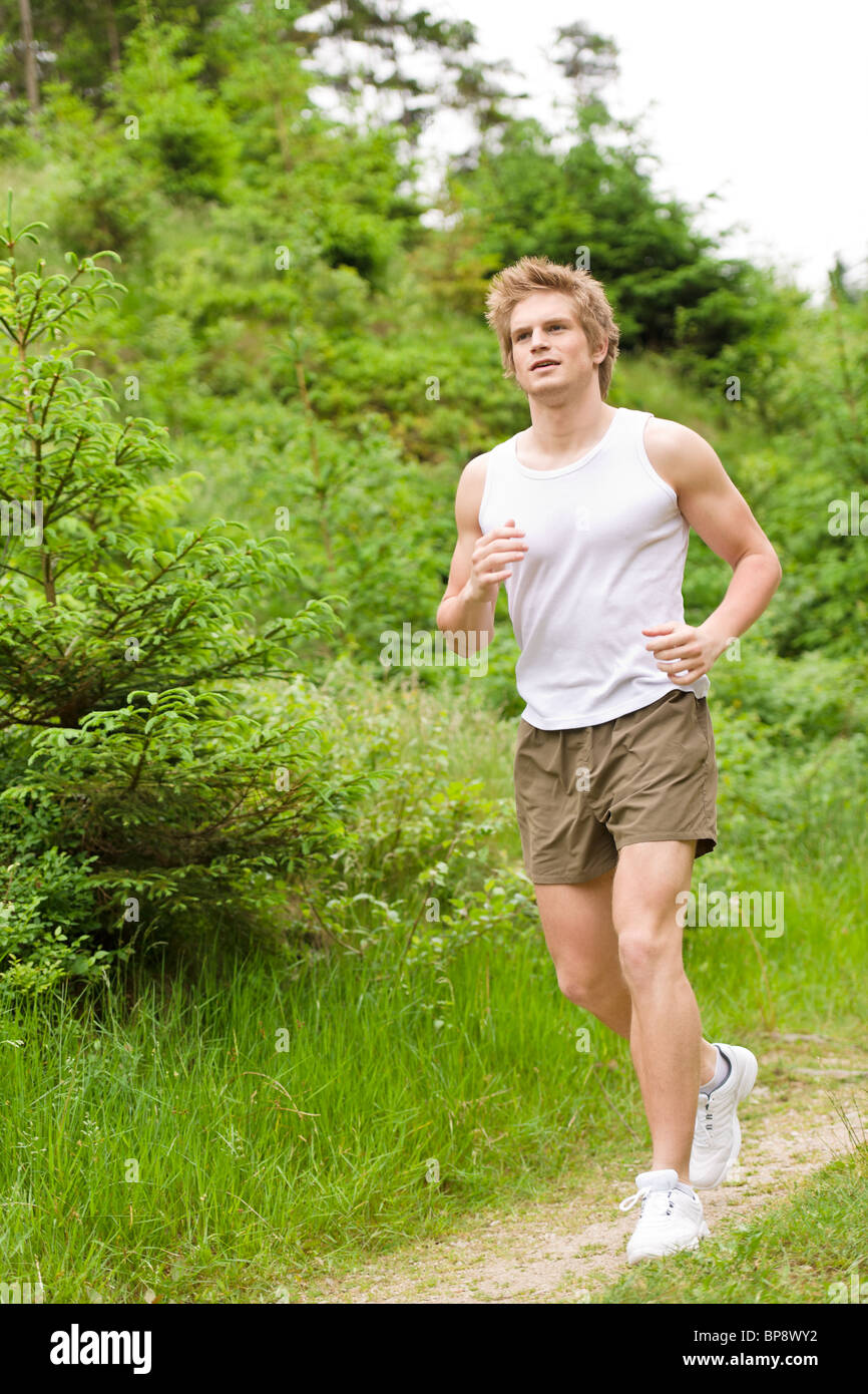 Young man jogging in nature in sportive outfit Stock Photo - Alamy